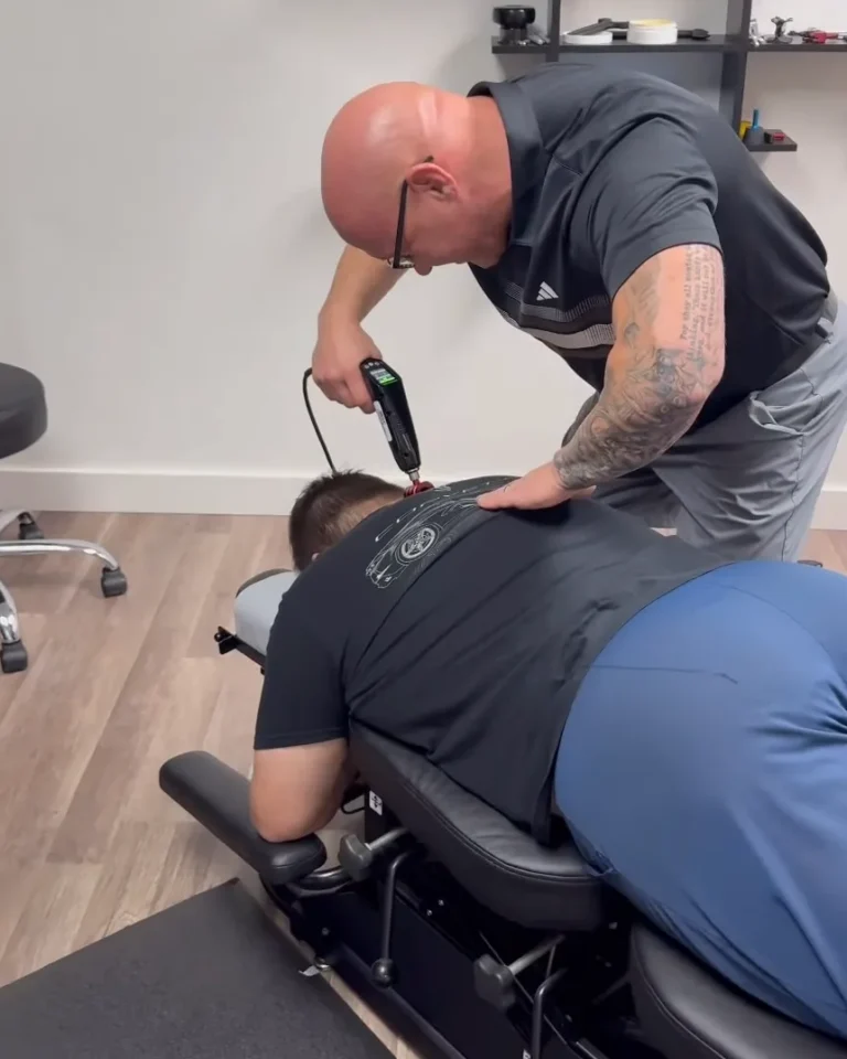 Dr. Tim Ballitch adjusting a patient's upper back with the ProAdjuster instrument at Muscle Chiropractic in Glendale